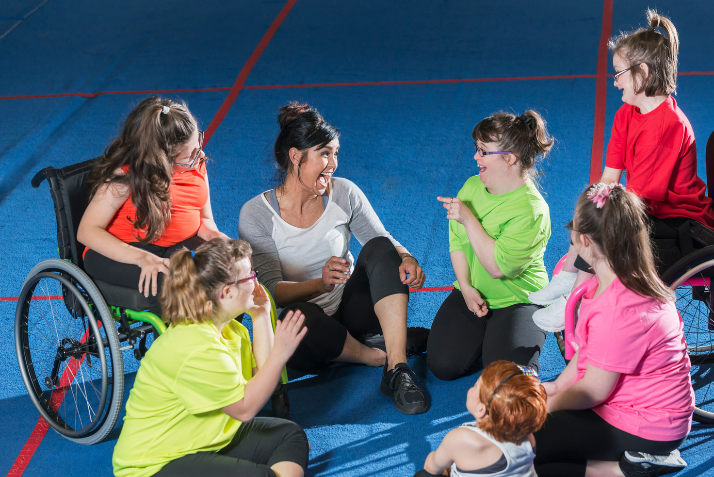 Group of special needs girls with instructor in gym